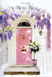 This scene shows a sunlit North London doorway that seems to breathe with hope and gentle celebration, as though captured just after a new homeowner in Stamford Hill has been handed their keys. At the heart of the image is a softly painted pink front door, its warm, rosy tone glowing against crisp whitewashed walls and a complementary pink shutter nearby. These pastel surfaces are embraced from above by an abundance of wisteria trailing down in romantic cascades of lavender and pale purple, the blossoms forming a loose, fragrant canopy over the entrance. Each wisteria strand drifts gracefully, brushing the edges of the doorframe and creating a natural, fluttering curtain that filters the sunlight. On the doorstep rests a stylish tin bucket, its light grey surface calmly grounding the composition. Inside, a generous bouquet of creamy white roses is arranged with the expert touch of a local florist used to serving homes around Stamford Hill and Tottenham. The roses, full and velvety, nestle among fresh, soft green foliage that spills lightly over the rim, giving the arrangement a relaxed yet refined feel. A delicate pink ribbon is tied neatly around the base of the bucket in a simple bow, echoing the tones of the door and tying the entire palette together. The light is gentle and golden, suggesting late afternoon or early evening, and it casts faint, shifting shadows from the wisteria onto the step. Altogether, the image conveys warmth, welcome, and a sense of new beginnings: flowers waiting patiently by the door, ready to be carried inside to mark the start of life in a new Stamford Hill home, filled with optimism and quiet joy.